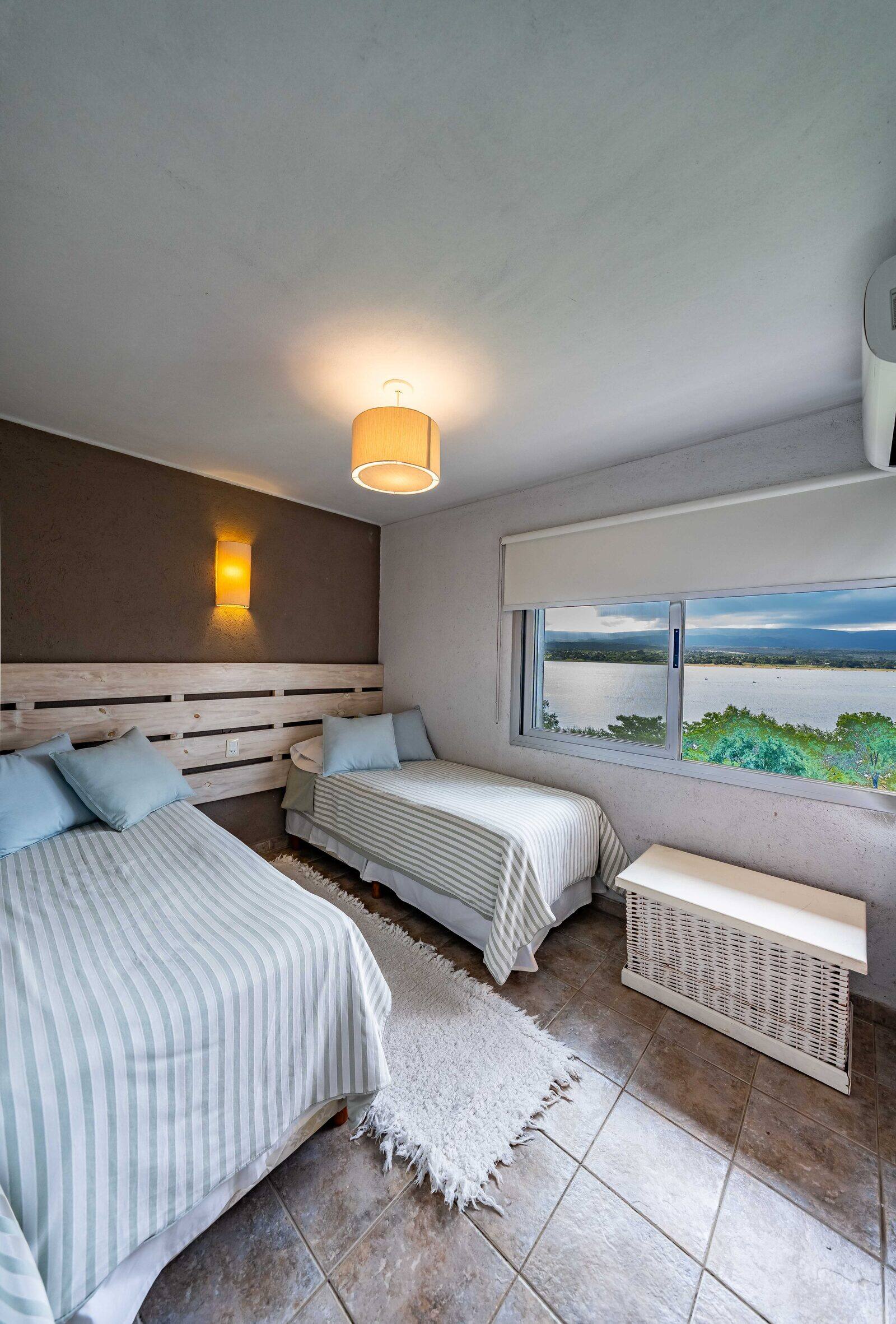 Segundo dormitorio con dos camas y el lago por la ventana