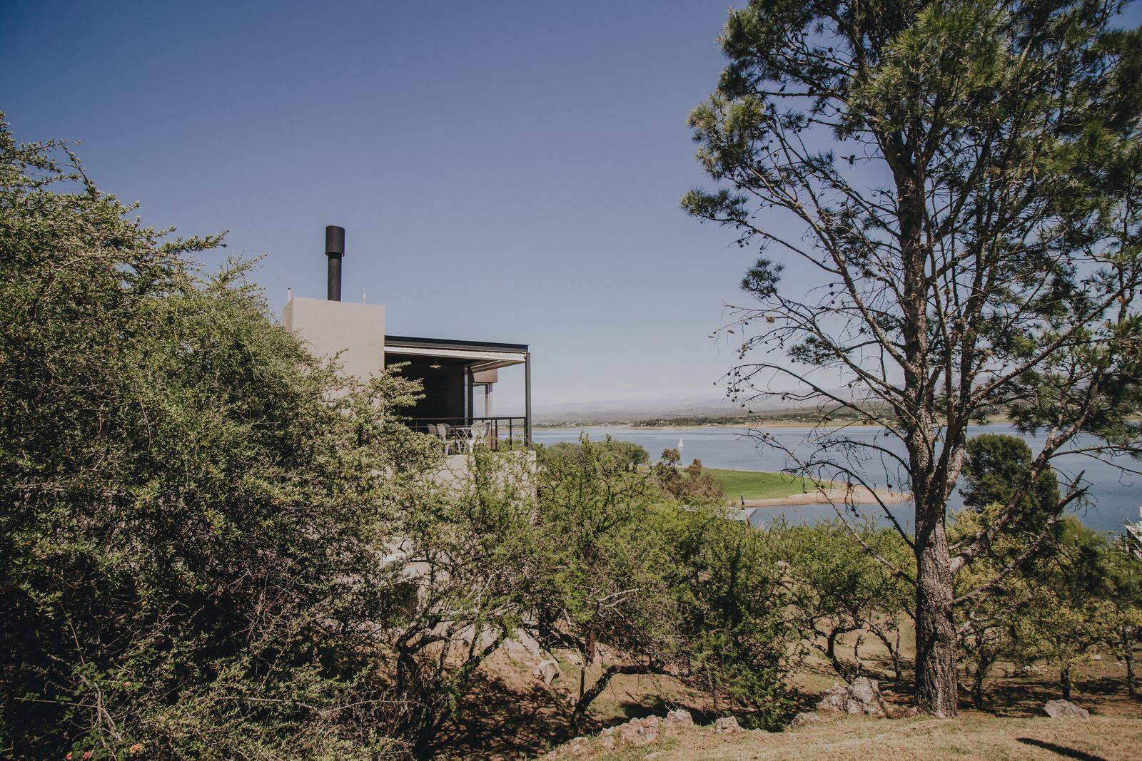 Casa del complejo entre el monte serrano con el lago detrás