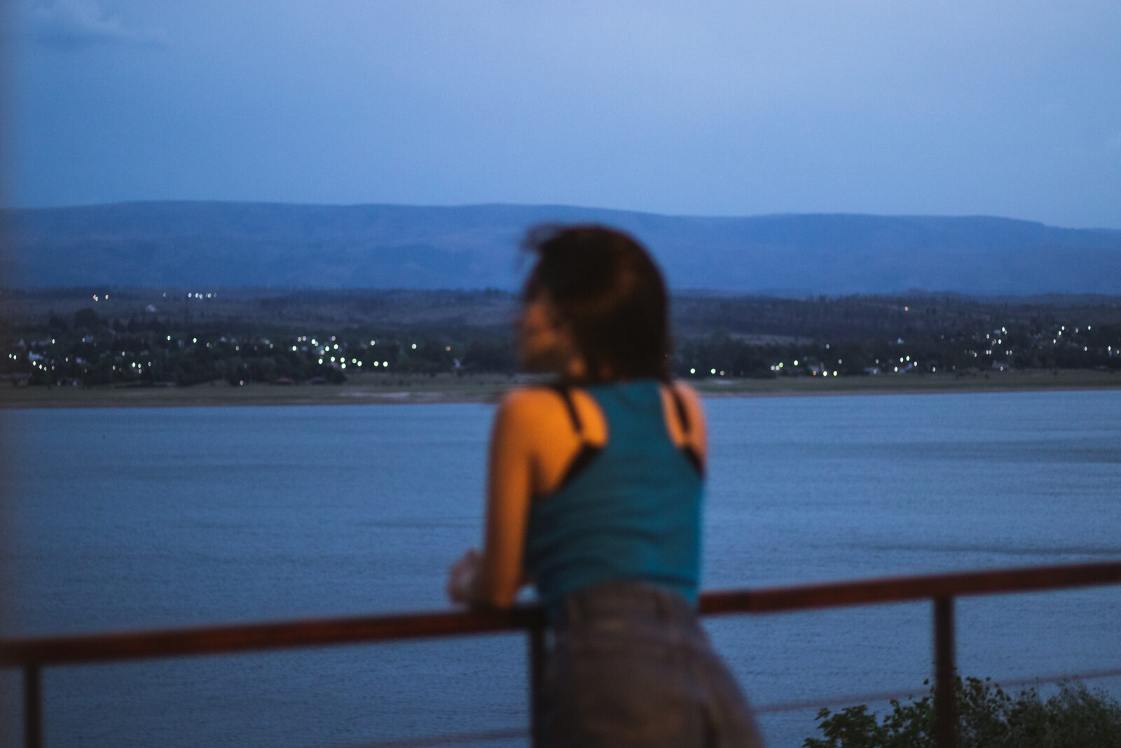 Una persona mirando el Lago Los Molinos desde la baranda, en calma
