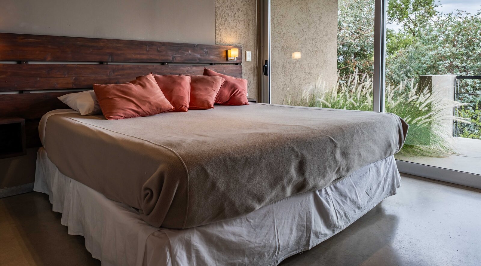 Cama del monoambiente con ventanal al lago