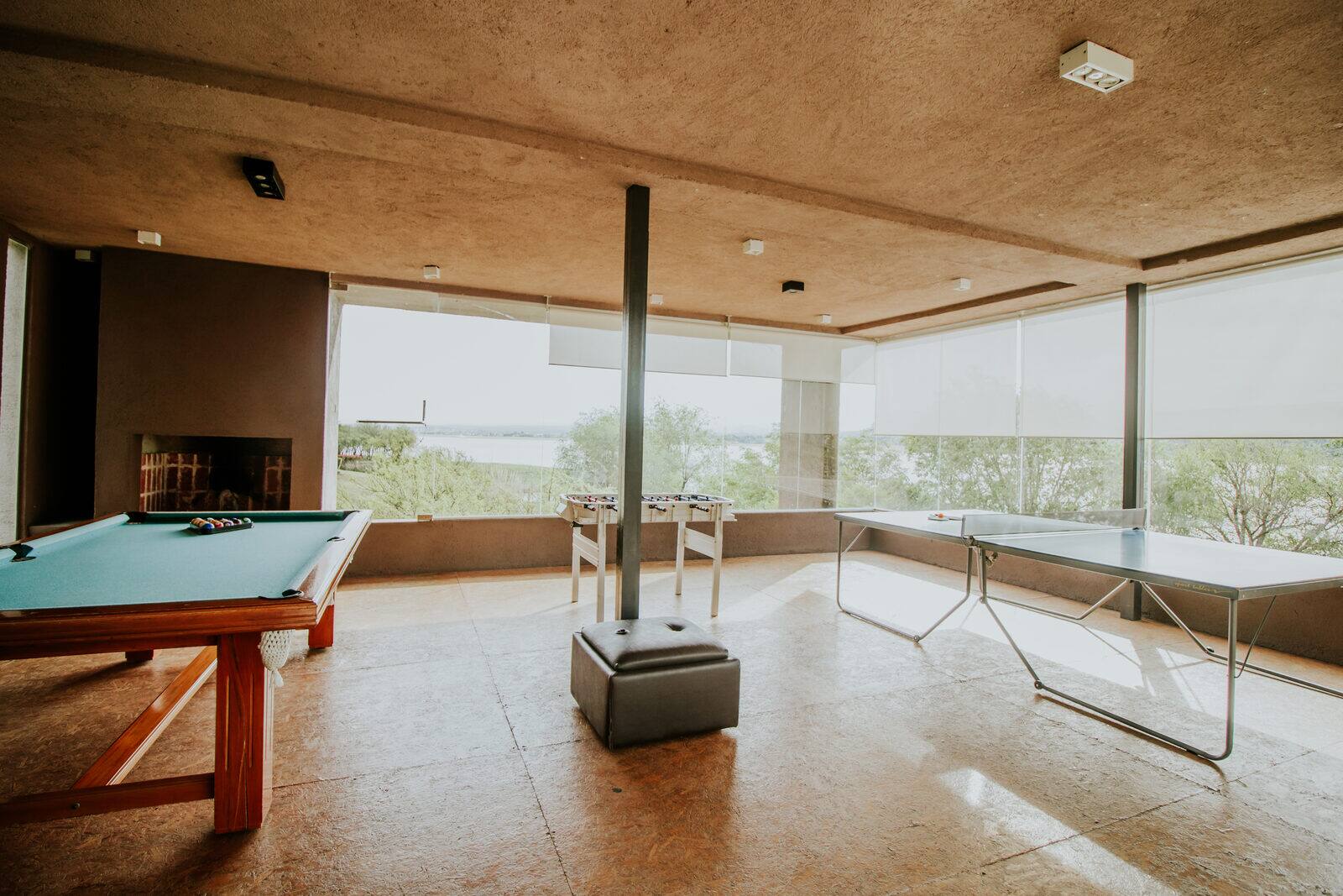 La sala de juegos con mesa de billar y ventanales al Lago Los Molinos